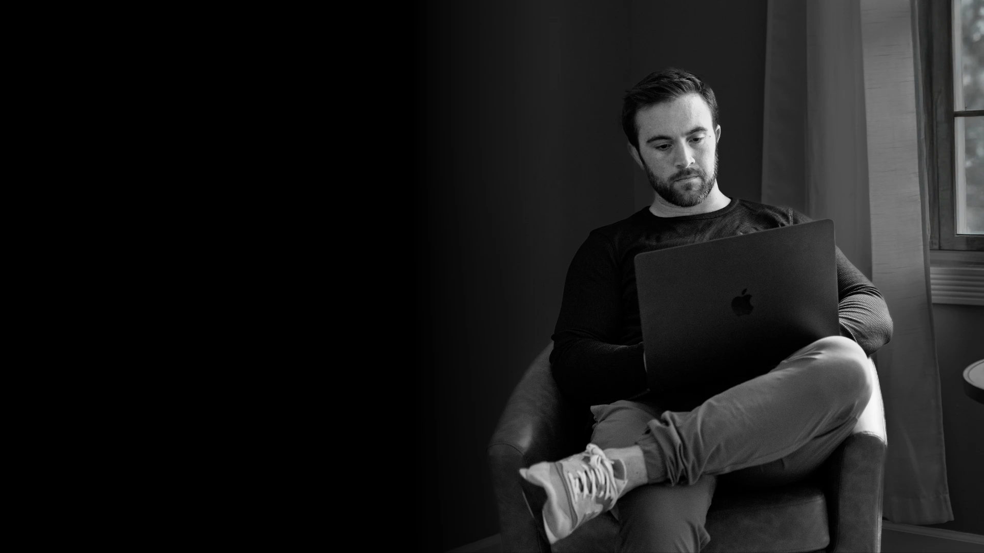 Reading on laptop by window